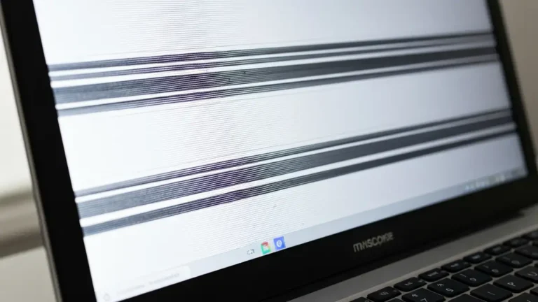 Laptop z migotającym ekranem pokazujący niestabilny obraz z czarnymi błyskami