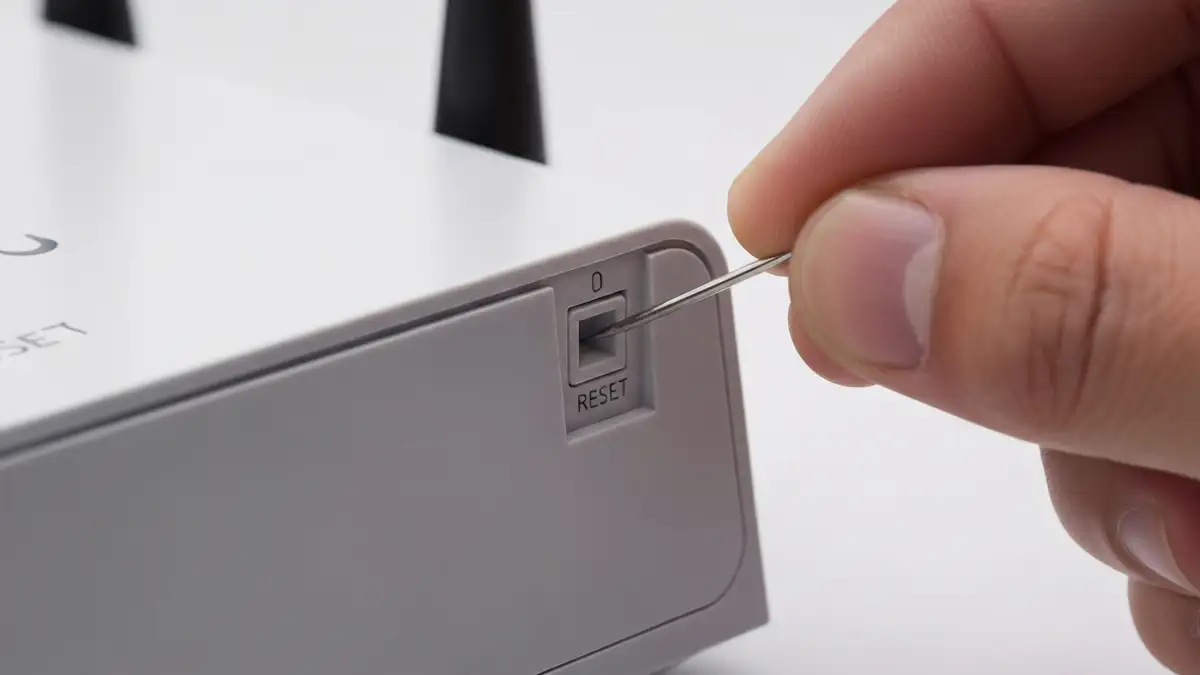 Przycisk reset na routerze WiFi - lokalizacja na obudowie, wcięty przycisk resetujący do ustawień fabrycznych